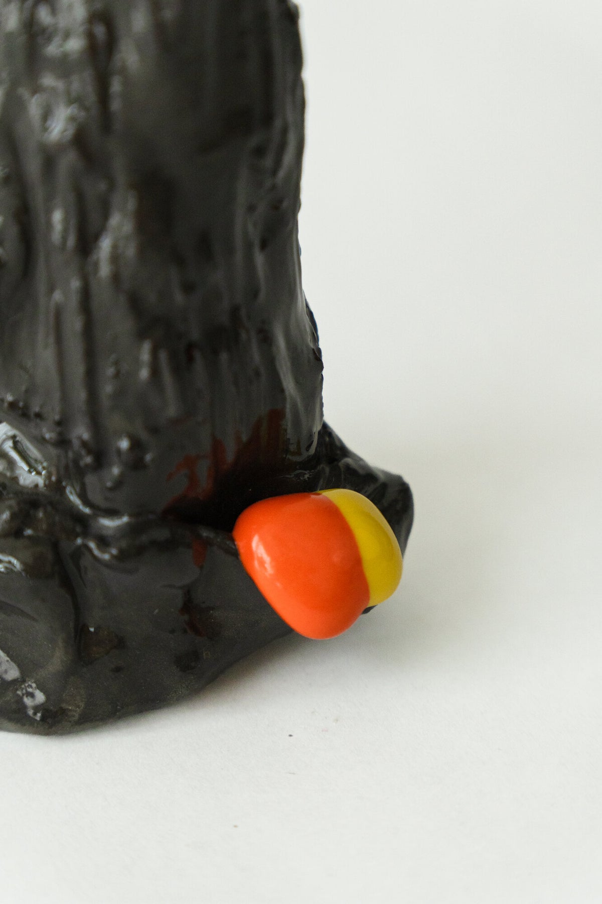 Foam #6 by Onree: Slender black ceramic form with an uneven surface and orange and yellow accents at its base — additional view 1