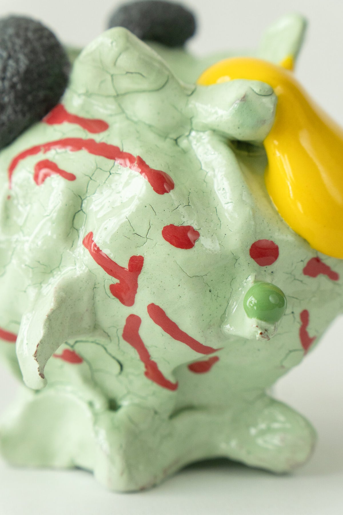 Foam #23 by Onree: Pale green ceramic vessel with red marks, dark textured circles and a yellow glazed detail — additional view 2