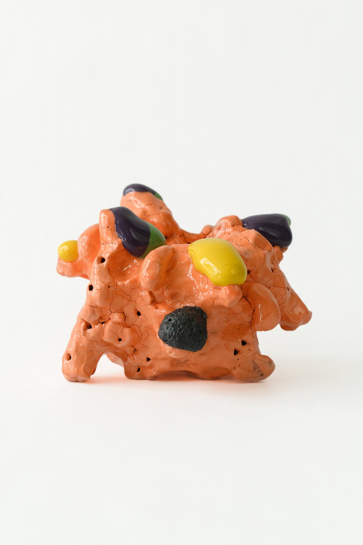 Foam #7 by Onree: Compact orange ceramic form with dark textured projections and yellow accents — full view