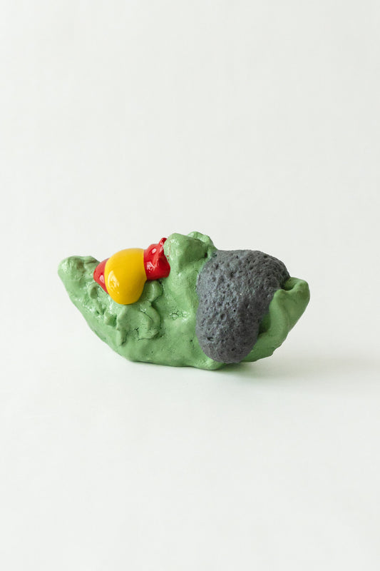 Foam #9 by Onree: Low green ceramic form with a dark textured section and glossy red and yellow additions — full view