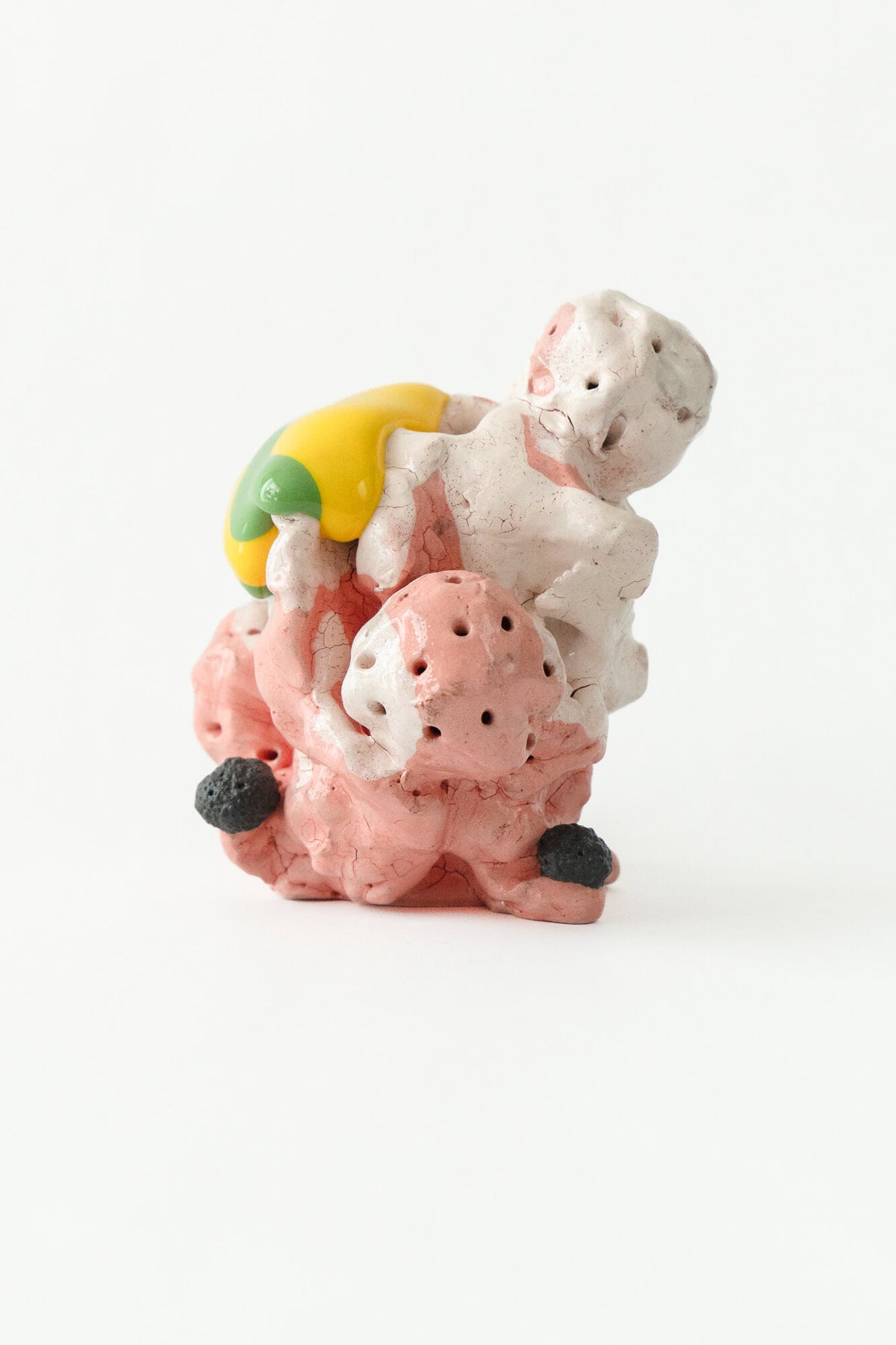 Foam #10 by Onree: Pink and cream ceramic form with small openings and a yellow-and-green accent — full view