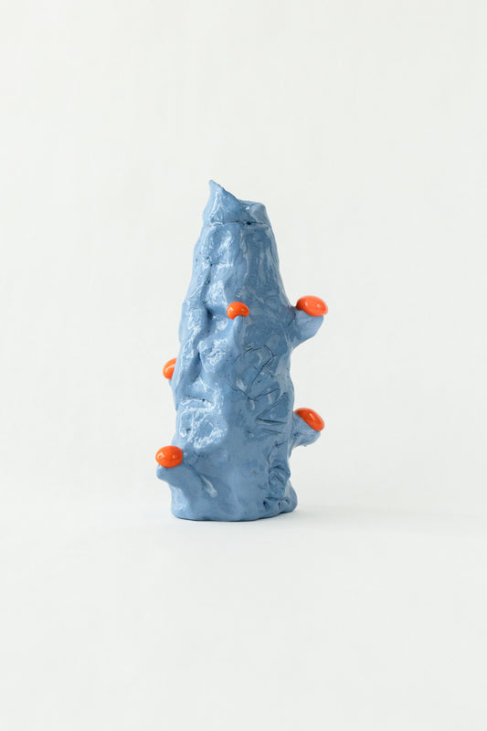 Foam #12 by Onree: Tall blue ceramic form with folded ridges and bright orange protrusions — full view