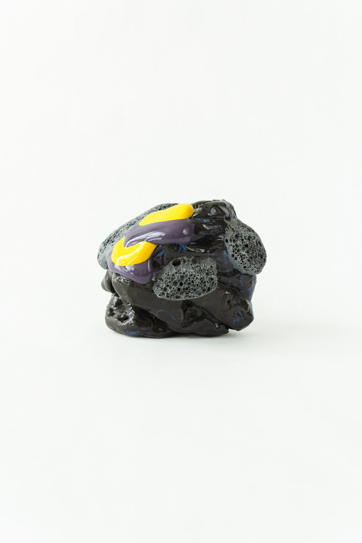 Foam #16 by Onree: Compact black ceramic form with textured grey details and yellow and purple glaze — full view