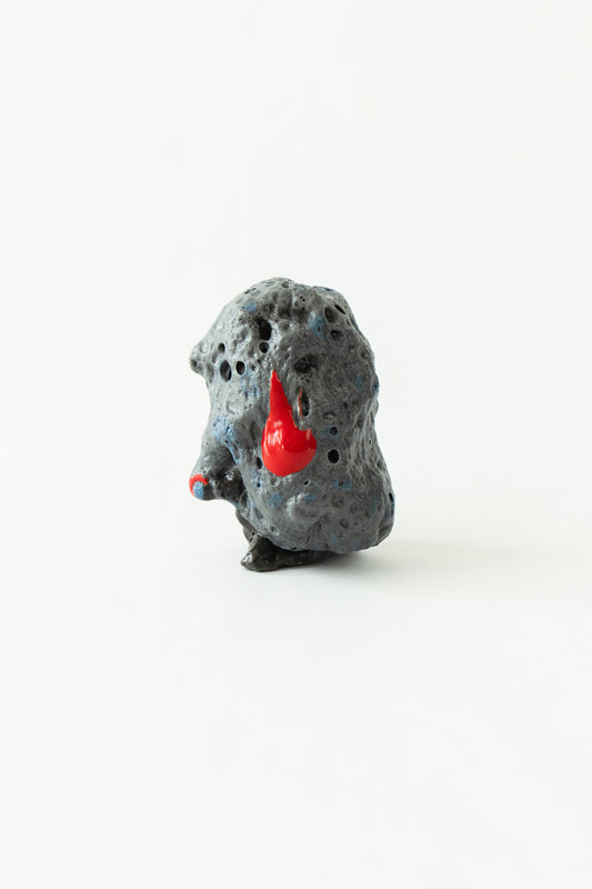 Foam #17 by Onree: Dark grey upright ceramic form with a pitted surface and red glazed accents — full view