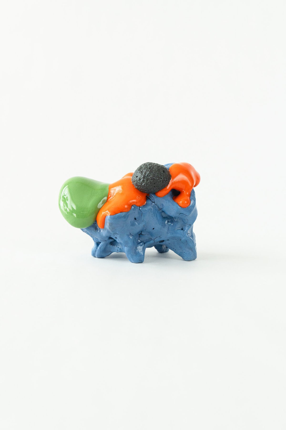 Foam #19 by Onree: Low blue ceramic form with orange glaze, a green projection and a dark textured disc — full view