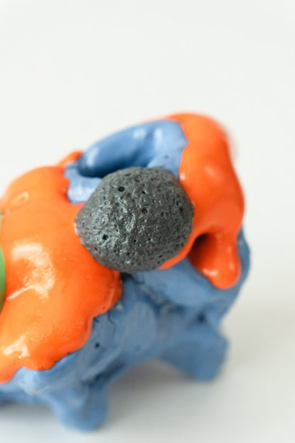 Foam #19 by Onree: Low blue ceramic form with orange glaze, a green projection and a dark textured disc — additional view 2