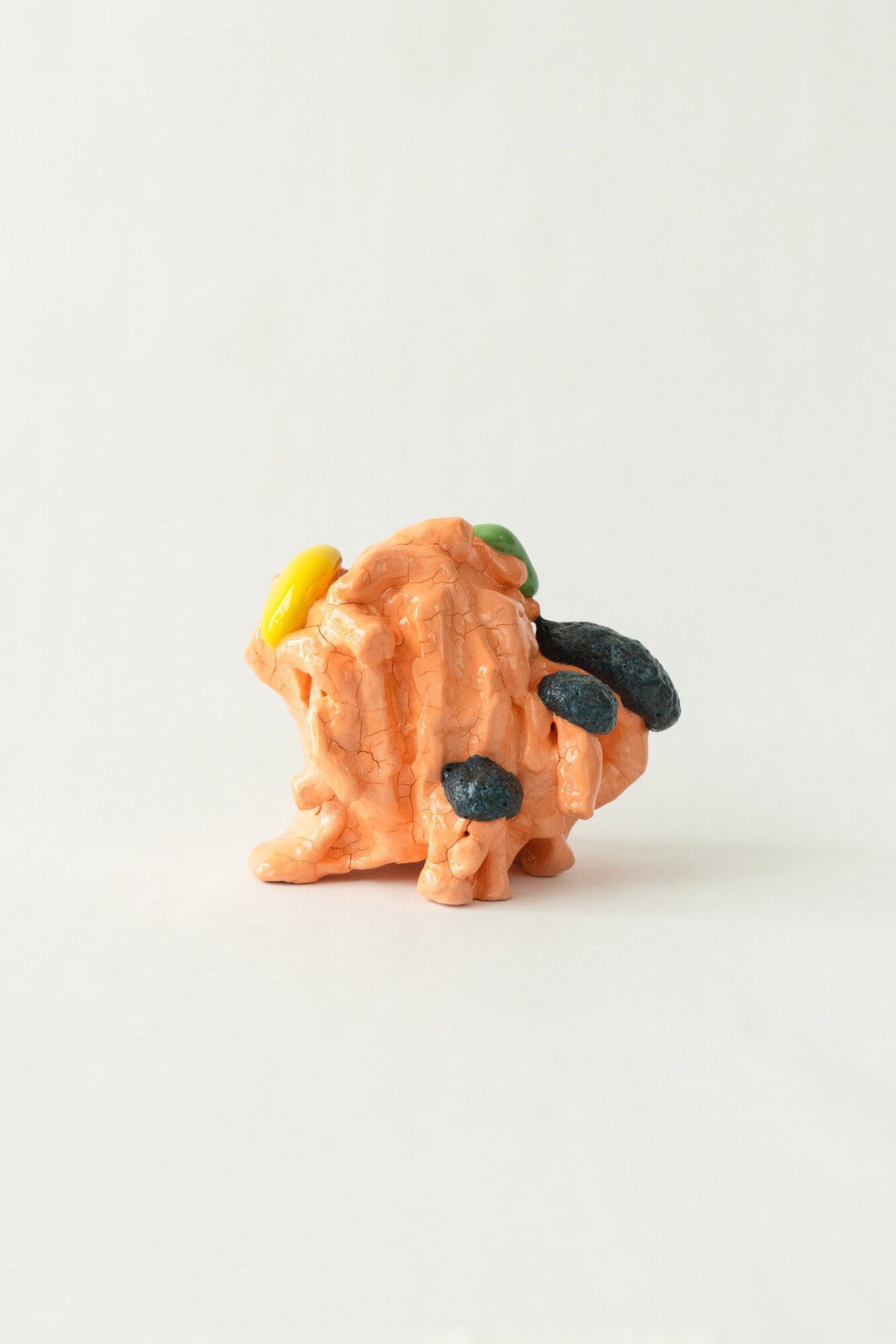 Foam #24 by Onree: Orange folded ceramic vessel with green and purple glaze and a dark side projection — full view