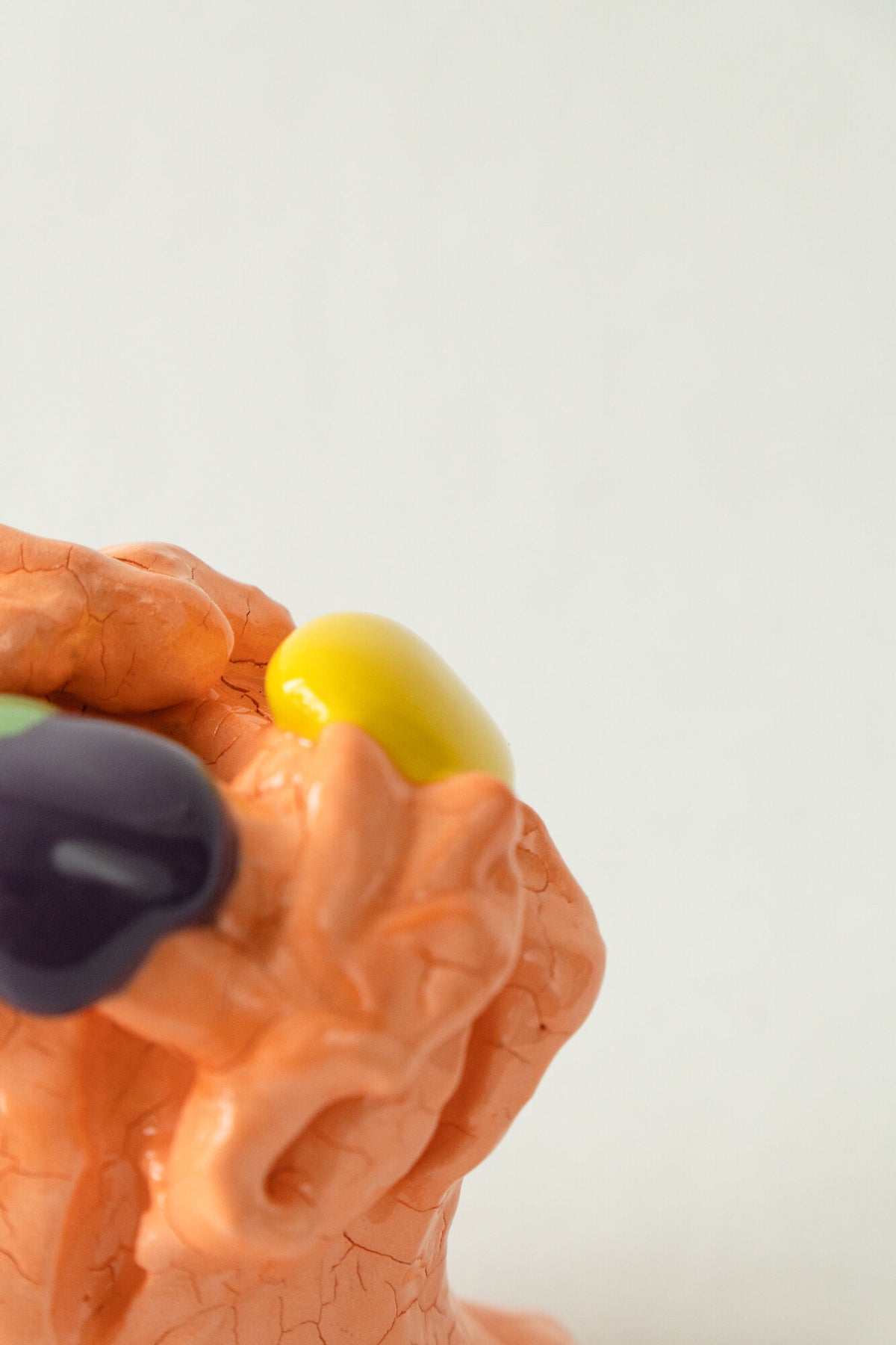 Foam #24 by Onree: Orange folded ceramic vessel with green and purple glaze and a dark side projection — additional view 1
