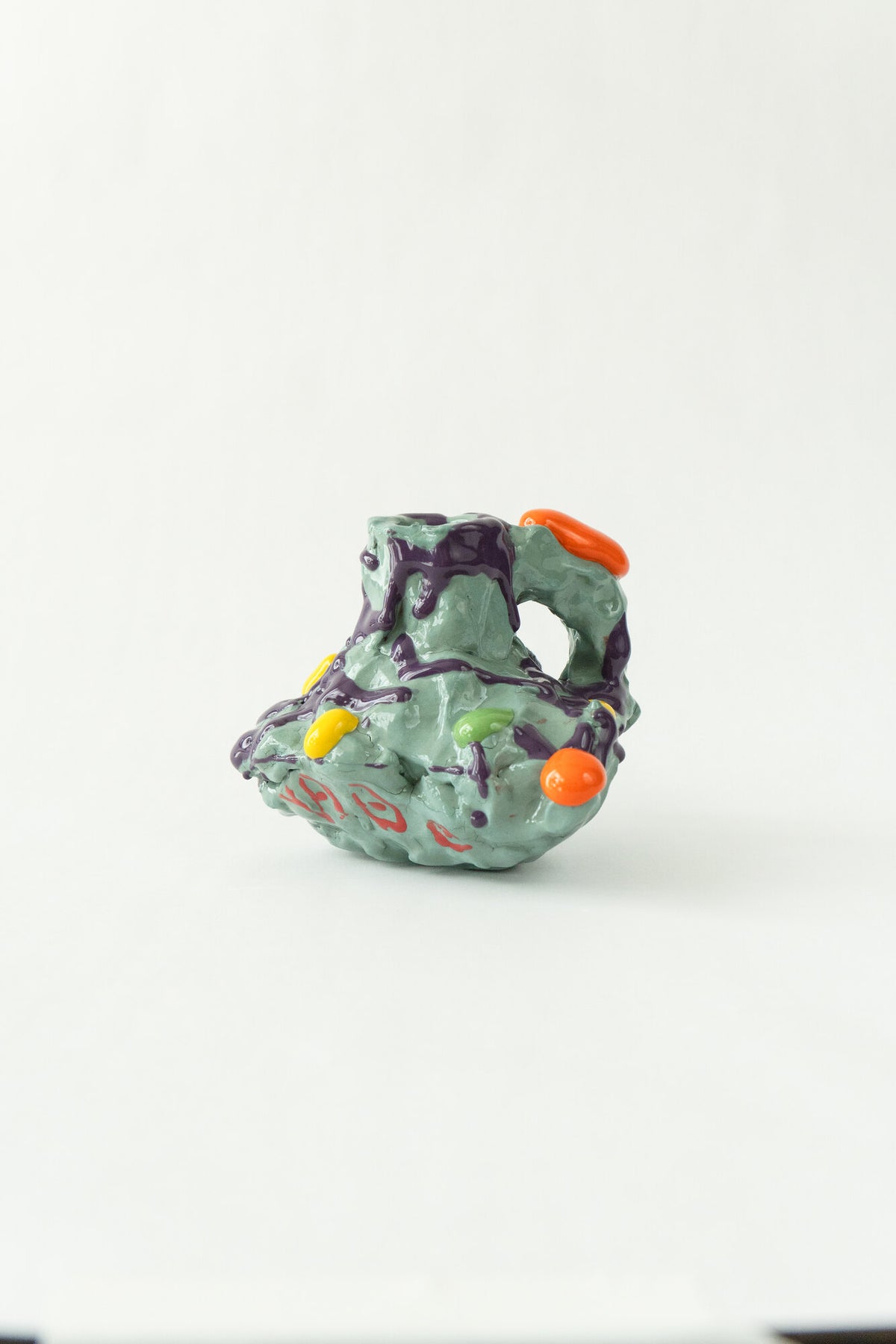 Foam #27 by Onree: Pale green ceramic vessel with deep openings, purple glaze and red marks — full view