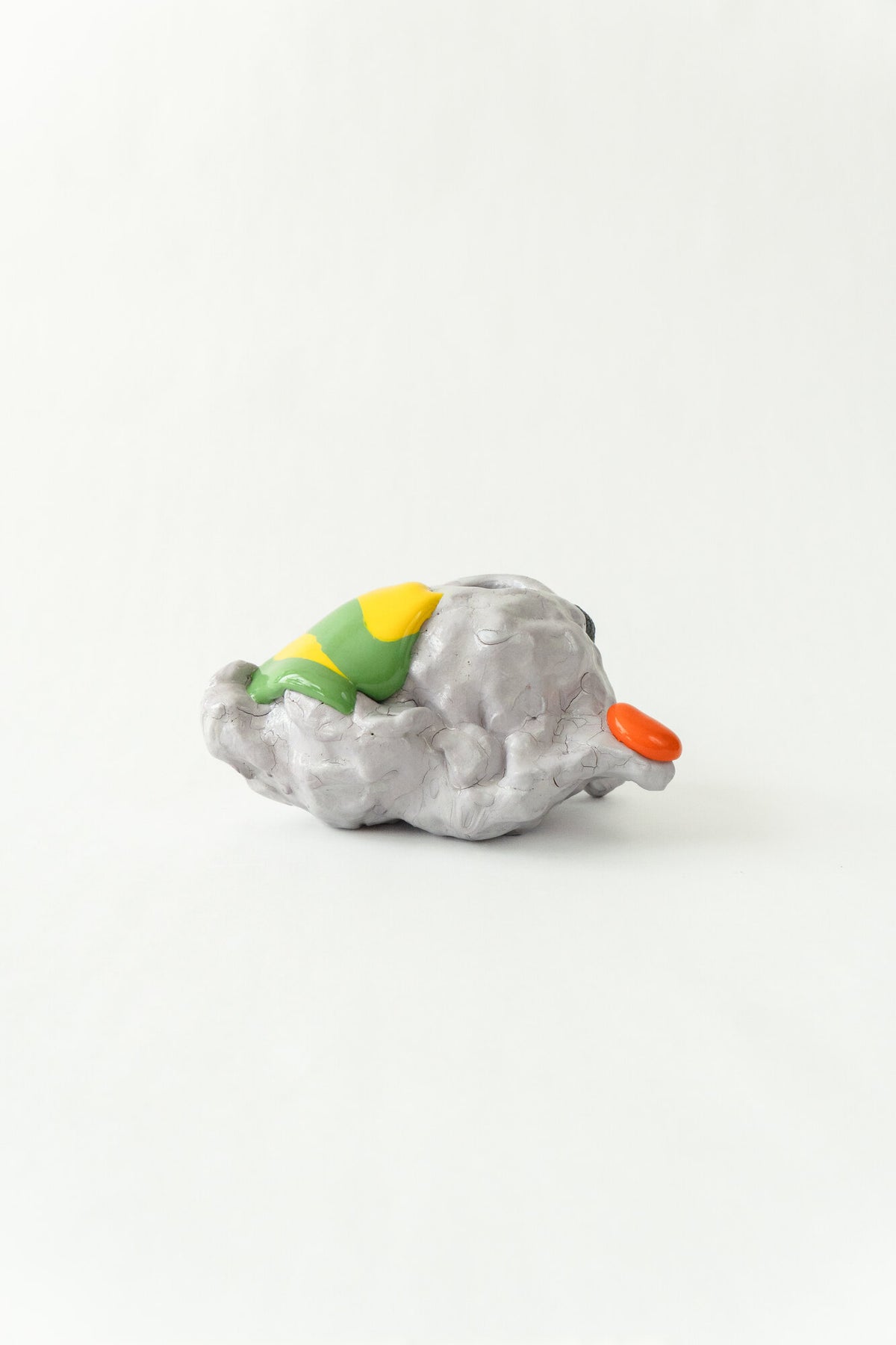 Foam #29 by Onree: Low white ceramic form with green, yellow and orange glaze and a dark textured detail — full view