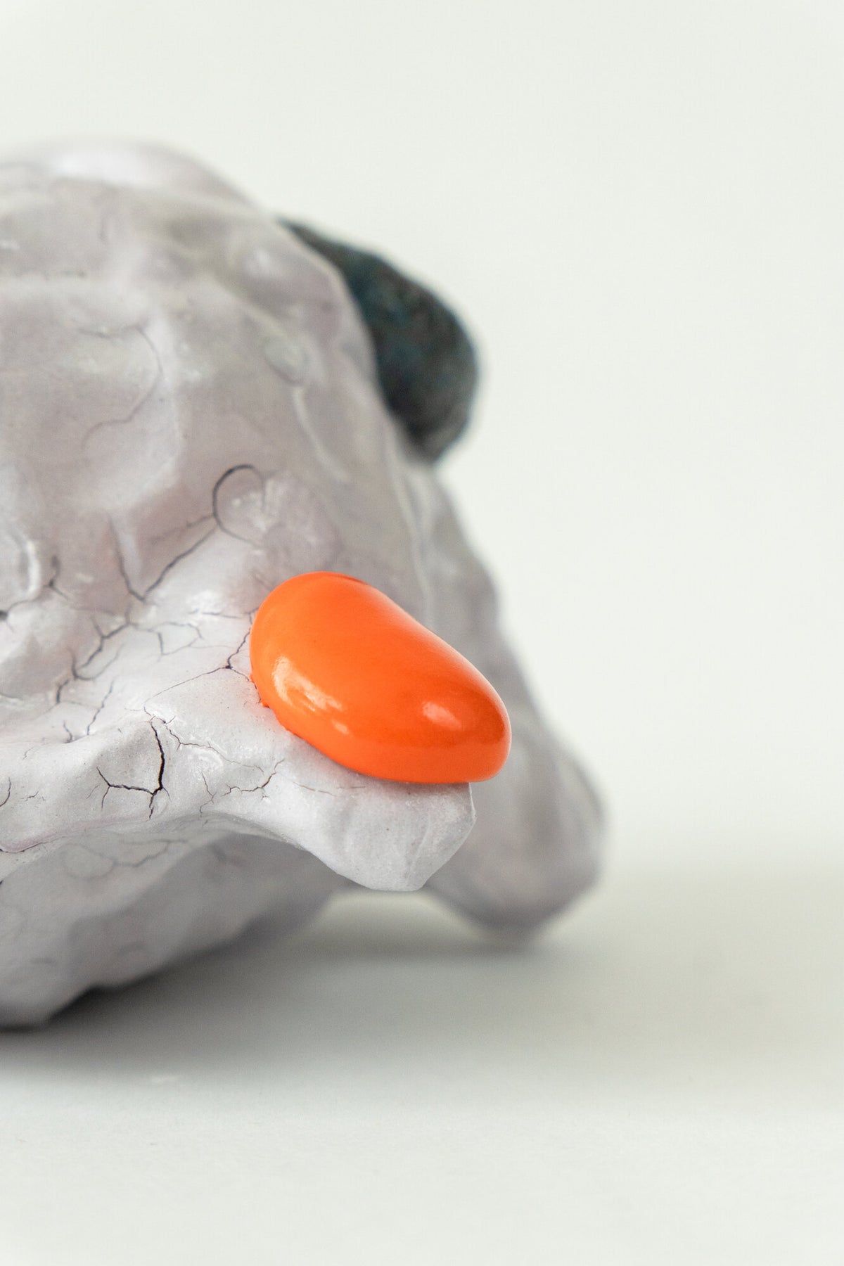 Foam #29 by Onree: Low white ceramic form with green, yellow and orange glaze and a dark textured detail — additional view 1