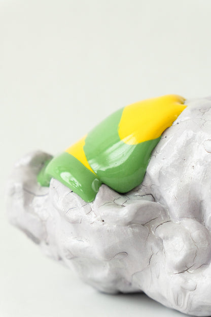 Foam #29 by Onree: Low white ceramic form with green, yellow and orange glaze and a dark textured detail — additional view 2