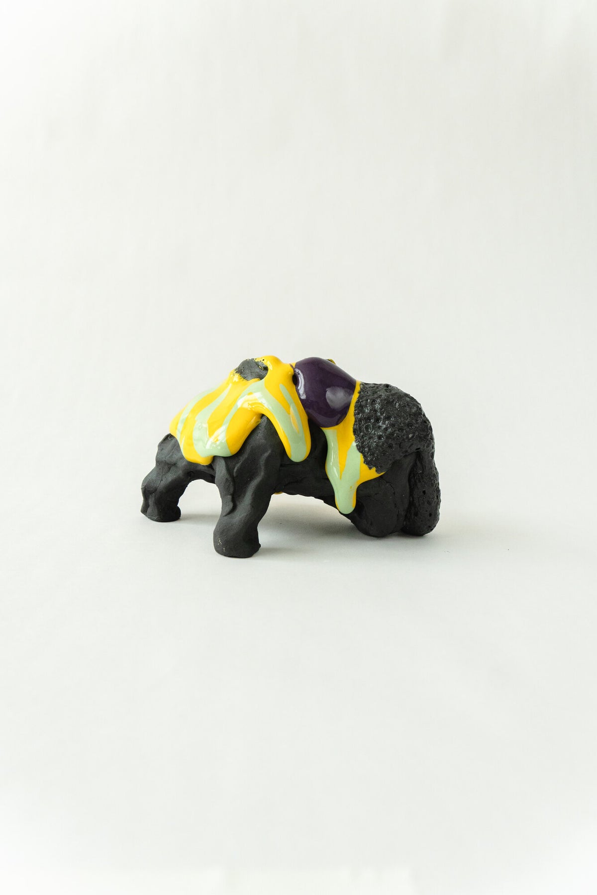 Foam #31 by Onree: Low black ceramic form with yellow, pale green and purple glaze — full view