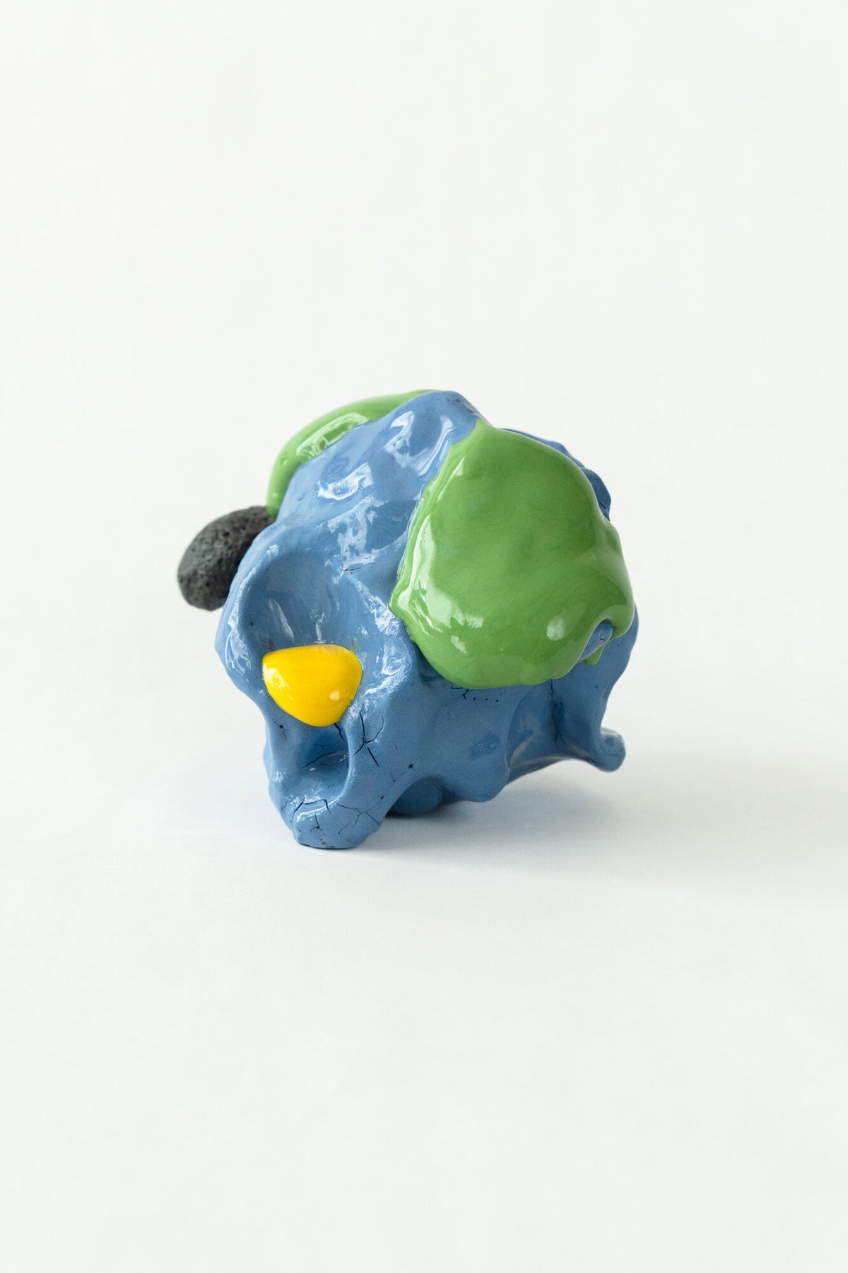 Foam #33 by Onree: Compact blue ceramic form with green glaze, a yellow accent and a dark textured projection — full view